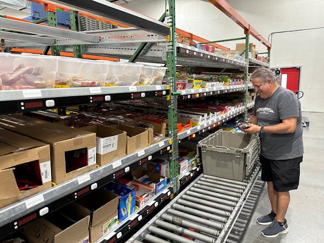 Quality Vending&apos;s Al Christofano pulling snacks in the warehouse.