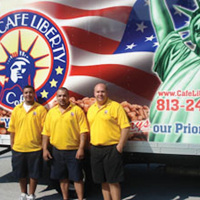 Angel Roman, left, and his father, Luis Figueroa, are also from New York. They join Frank in front of a delivery truck bearing a patriotic logo. Many of the company&rsquo;s customers moved to Florida from the New York metro area.